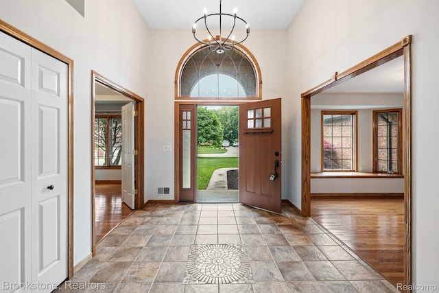 26569 Autumn Lake Dr, Chesterfield, MI 48051 - entryway with healthy amount of natural light, a chandelier, baseboards, a high ceiling, and light stone finish flooring