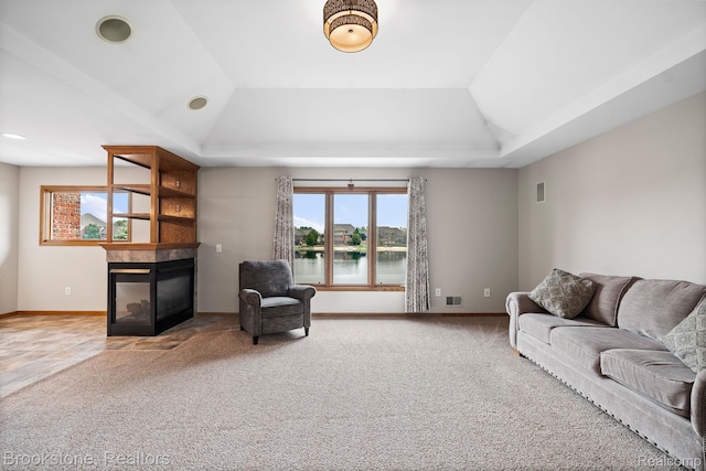 26569 Autumn Lake Dr, Chesterfield, MI 48051 - carpeted living area with a multi sided fireplace, a tray ceiling, lofted ceiling, baseboards, and a water view
