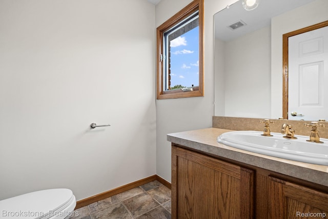 26569 Autumn Lake Dr, Chesterfield, MI 48051 - bathroom with baseboards, vanity, toilet, and stone finish flooring