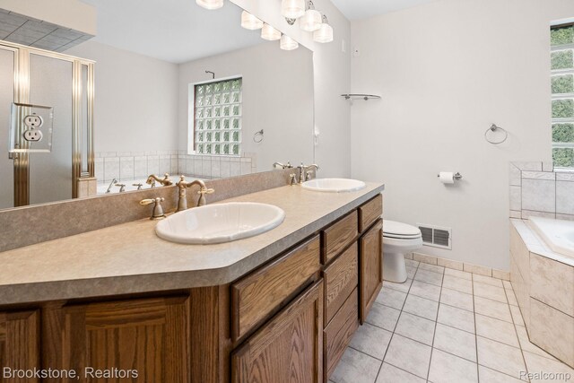 26569 Autumn Lake Dr, Chesterfield, MI 48051 - bathroom featuring double vanity, tile patterned floors, a garden tub, a stall shower, and toilet