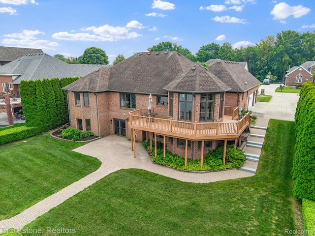 26569 Autumn Lake Dr, Chesterfield, MI 48051 - rear view of property featuring brick siding, driveway, a deck, a yard, and a shingled roof