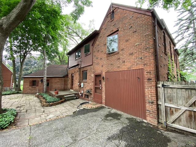 27943 Sunset Blvd W, Lathrup Village, MI 48076 - back of house featuring brick siding, a patio area, and a gate