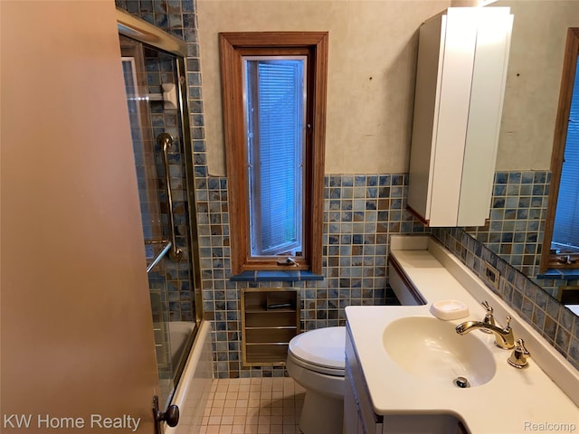 27943 Sunset Blvd W, Lathrup Village, MI 48076 - bathroom featuring tile walls, tile patterned floors, vanity, bath / shower combo with glass door, and wainscoting