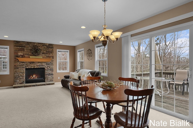 7165 Keystone Ct, Jenison, MI 49428 - dining area featuring a chandelier, healthy amount of natural light, recessed lighting, a stone fireplace, and light carpet
