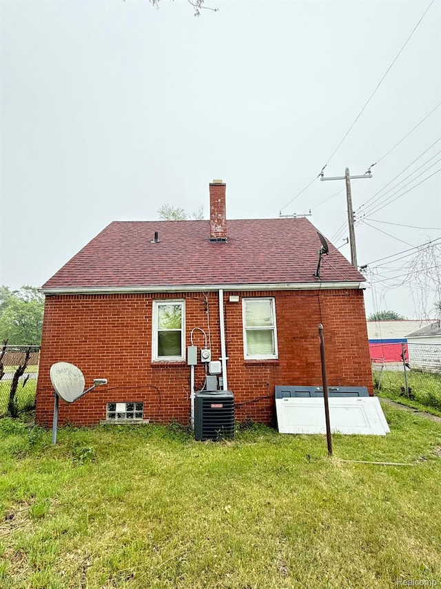 12827 Dwyer St, Hamtramck, MI 48212 - rear view of property featuring a chimney, roof with shingles, central AC, and brick siding