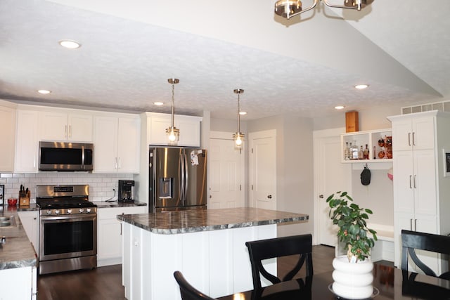 3290 Signal Point Dr, Allegan, MI 49010 - kitchen featuring appliances with stainless steel finishes, white cabinetry, dark wood-type flooring, dark countertops, and recessed lighting