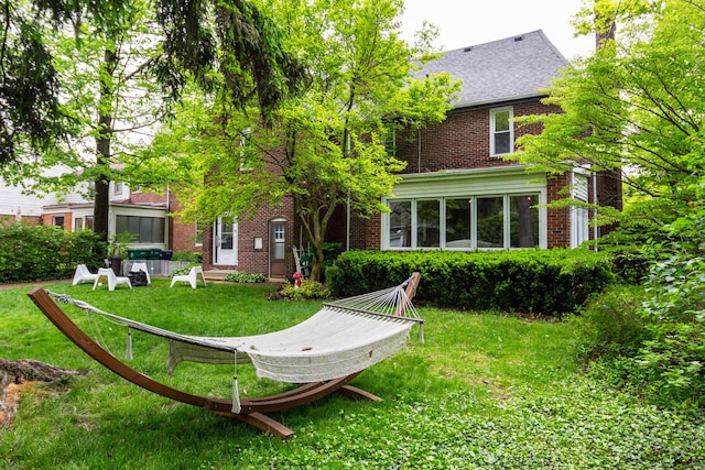 953 Berkshire Rd, Grosse Pointe Park, MI 48230 - rear view of house with brick siding, a yard, and roof with shingles