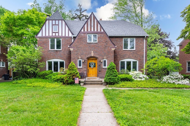 953 Berkshire Rd, Grosse Pointe Park, MI 48230 - tudor house featuring brick siding, a front yard, a shingled roof, and a chimney