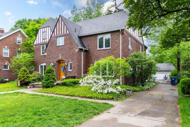 953 Berkshire Rd, Grosse Pointe Park, MI 48230 - tudor house with brick siding, board and batten siding, roof with shingles, and a front yard