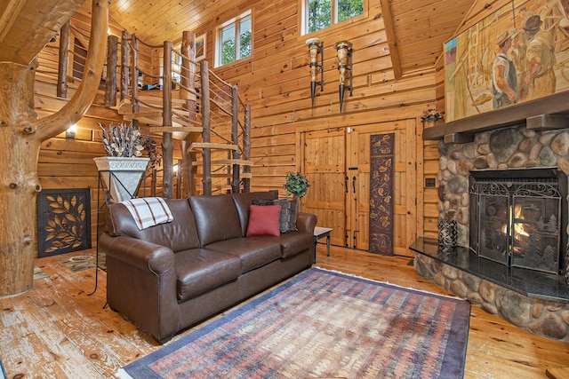 1547 N Dennis Rd, Ludington, MI 49431 - living room featuring a stone fireplace, wood ceiling, high vaulted ceiling, wood-type flooring, and wooden walls