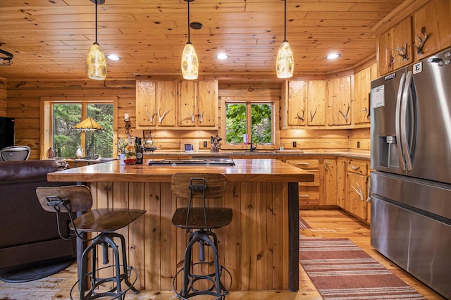 1547 N Dennis Rd, Ludington, MI 49431 - kitchen with stainless steel refrigerator with ice dispenser, butcher block counters, wooden ceiling, a kitchen breakfast bar, and light wood-style flooring