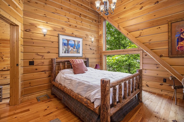 1547 N Dennis Rd, Ludington, MI 49431 - bedroom with wood-type flooring, a chandelier, wood walls, and vaulted ceiling