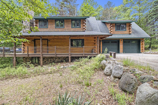 1547 N Dennis Rd, Ludington, MI 49431 - log home with log siding, a garage, concrete driveway, and a shingled roof