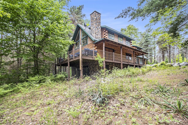 1547 N Dennis Rd, Ludington, MI 49431 - back of property featuring a chimney, a wooden deck, and stone siding
