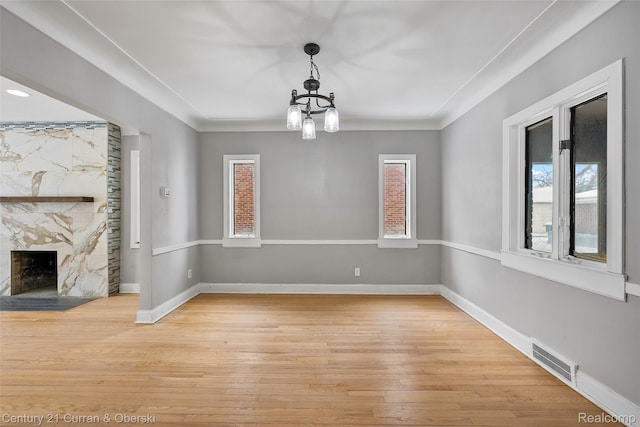 19191 Littlefield St, Detroit, MI 48235 - unfurnished dining area featuring light wood-style floors, a premium fireplace, baseboards, and a chandelier