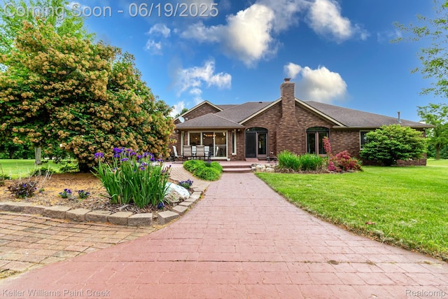 75757 Peters Dr, Bruce, MI 48065 - view of front facade with a front lawn, brick siding, a chimney, and covered porch