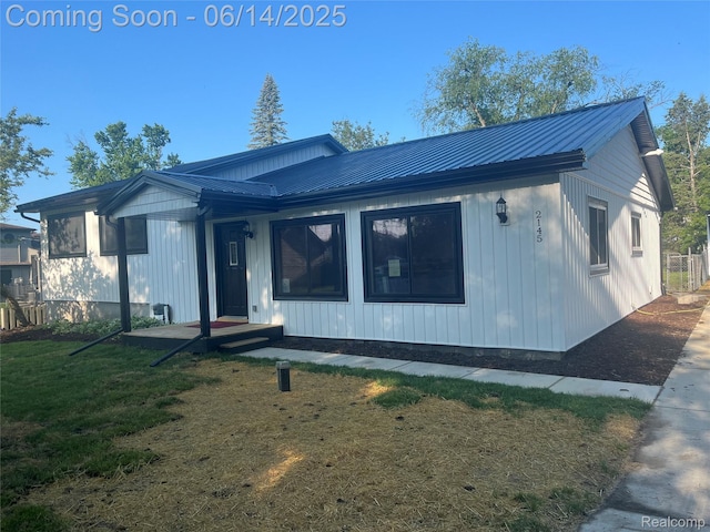 2145 Terrapin St, Wolverine Lake, MI 48390 - view of front of property featuring a metal roof, a front yard, and board and batten siding