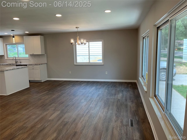 2145 Terrapin St, Wolverine Lake, MI 48390 - kitchen featuring a chandelier, white cabinetry, dark wood-type flooring, light stone counters, and pendant lighting