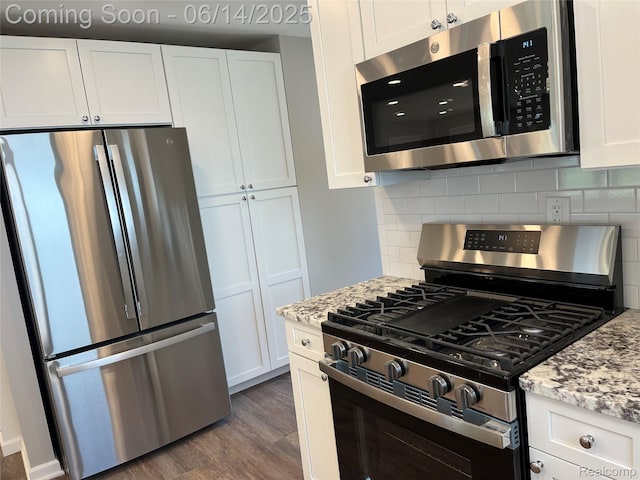 2145 Terrapin St, Wolverine Lake, MI 48390 - kitchen featuring appliances with stainless steel finishes, white cabinets, tasteful backsplash, and dark wood-style floors