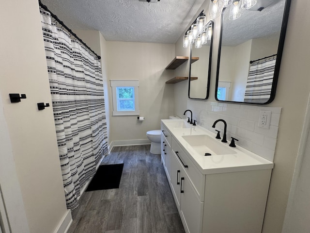 145 Sycamore St, Jackson, MI 49202 - bathroom with a textured ceiling, wood finished floors, backsplash, and double vanity