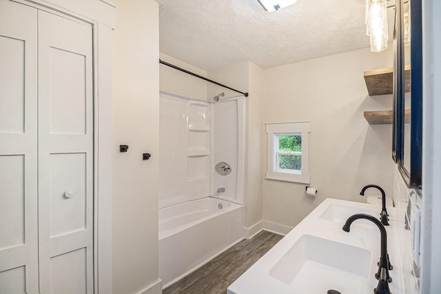 145 Sycamore St, Jackson, MI 49202 - full bathroom featuring wood finished floors, a textured ceiling, bathing tub / shower combination, and double vanity
