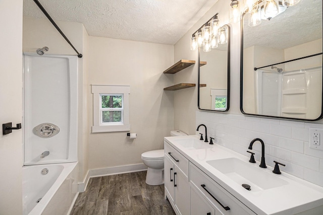 145 Sycamore St, Jackson, MI 49202 - bathroom featuring a textured ceiling, tasteful backsplash, wood finished floors, double vanity, and shower / tub combination