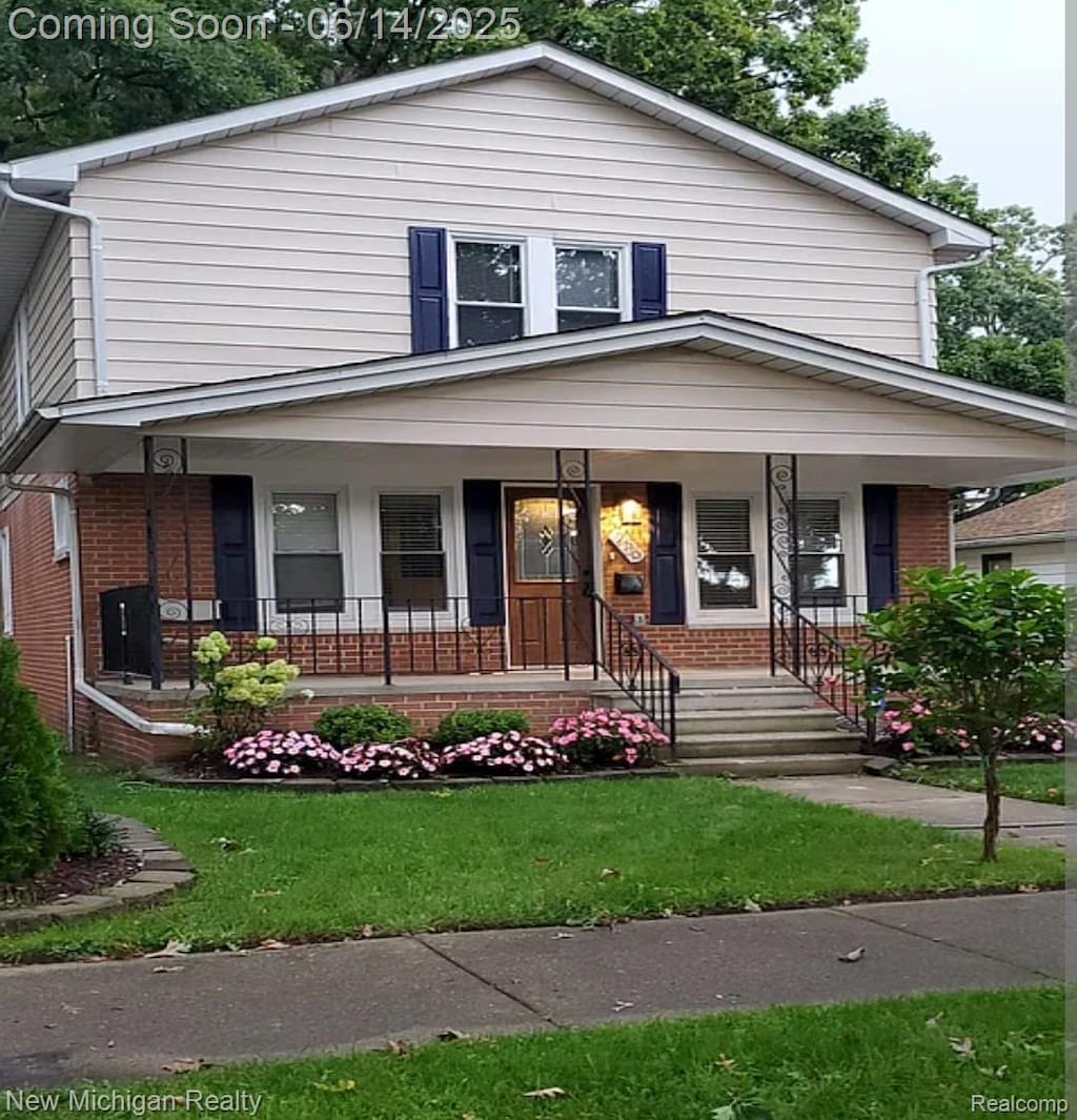 256 W Chicago Ave, Pontiac, MI 48340 - view of front facade with brick siding, covered porch, and a front lawn