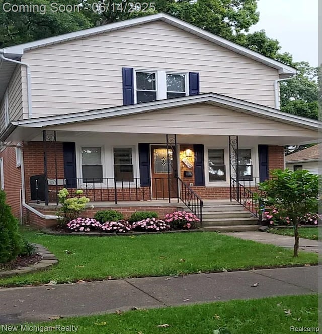 256 W Chicago Ave, Pontiac, MI 48340 - view of front facade with brick siding, covered porch, and a front lawn