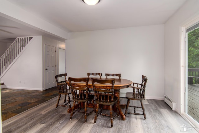 45510 Arkona Rd, Belleville, MI 48111 - dining area featuring a baseboard heating unit, stairs, wood finished floors, and baseboards