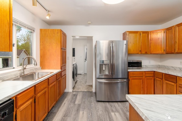45510 Arkona Rd, Belleville, MI 48111 - kitchen featuring appliances with stainless steel finishes, a sink, light wood-style flooring, separate washer and dryer, and light countertops