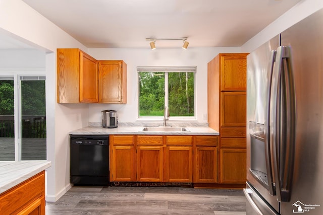 45510 Arkona Rd, Belleville, MI 48111 - kitchen featuring stainless steel fridge, black dishwasher, a sink, light countertops, and brown cabinetry