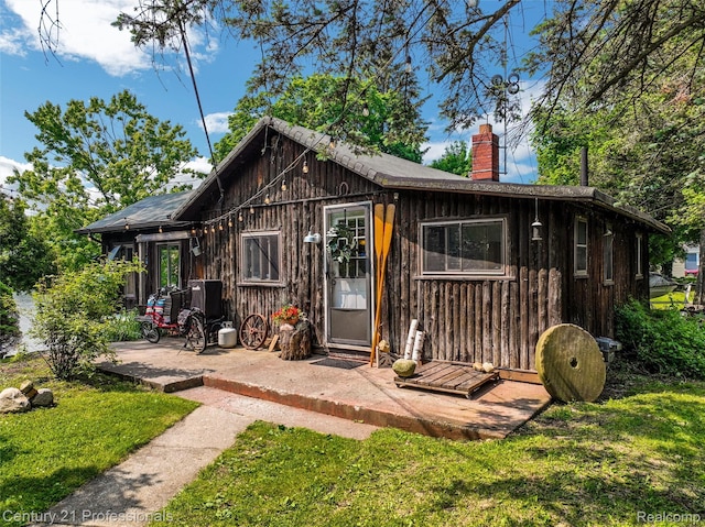 9233 Evee Rd, Clarkston, MI 48348 - back of house featuring a chimney, a yard, and a patio