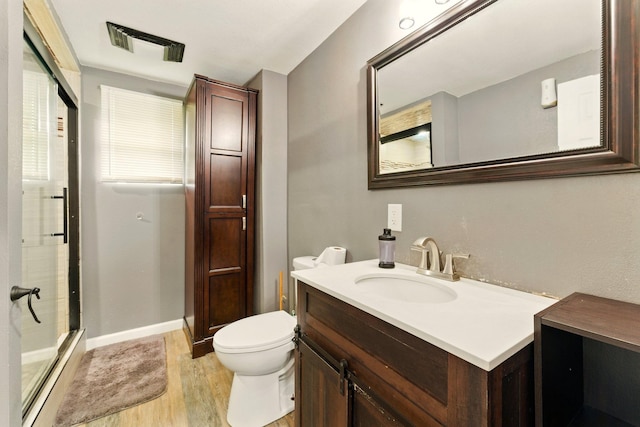 3307 Brookfield Ave, Kalamazoo, MI 49048 - bathroom featuring wood finished floors, an enclosed shower, vanity, toilet, and baseboards