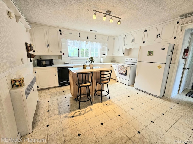 7257 Miller Rd, Swartz Creek, MI 48473 - kitchen featuring black appliances, white cabinets, light countertops, a textured ceiling, and a wainscoted wall