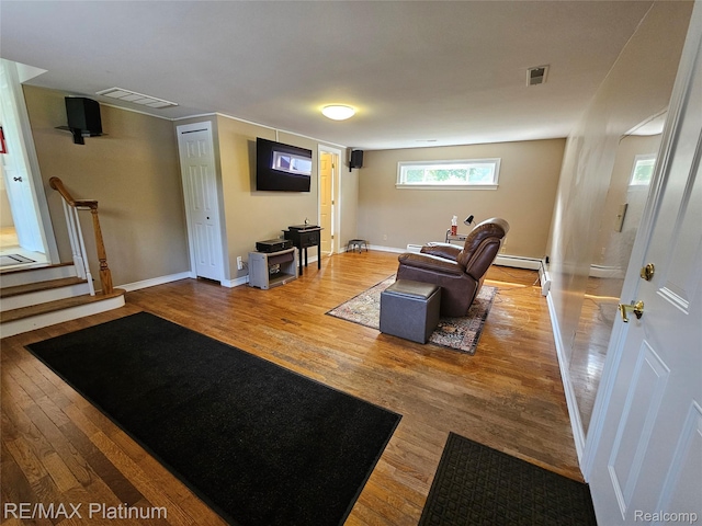 7257 Miller Rd, Swartz Creek, MI 48473 - living room featuring wood finished floors, baseboards, stairs, and a baseboard heating unit