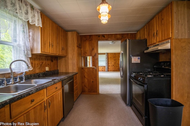 3118 W 104th St, Grant, MI 49327 - kitchen with black gas range, stainless steel dishwasher, a sink, under cabinet range hood, and brown cabinets