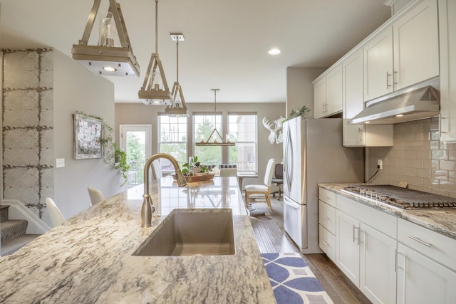 2605 Helmsdale Cir, Rochester, MI 48307 - kitchen with under cabinet range hood, a sink, stainless steel appliances, light stone counters, and dark wood-type flooring