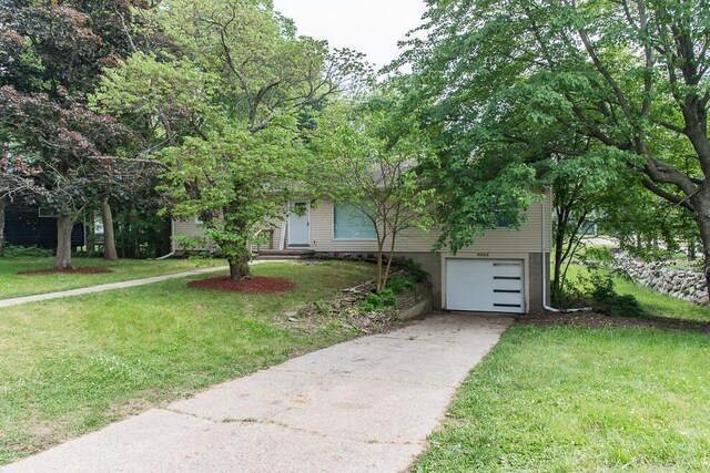 6604 E H Ave, Kalamazoo, MI 49048 - view of property hidden behind natural elements featuring an attached garage, a front lawn, and driveway
