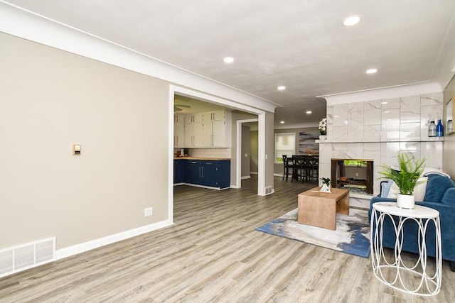 6604 E H Ave, Kalamazoo, MI 49048 - living room with light wood-style floors, baseboards, recessed lighting, a premium fireplace, and crown molding