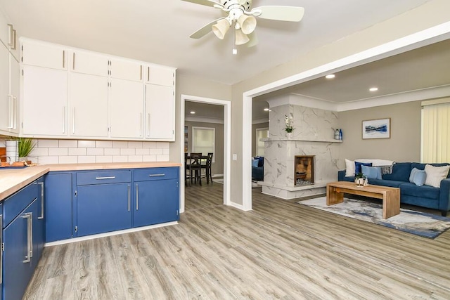 6604 E H Ave, Kalamazoo, MI 49048 - kitchen with blue cabinetry, open floor plan, light wood finished floors, ceiling fan, and white cabinets