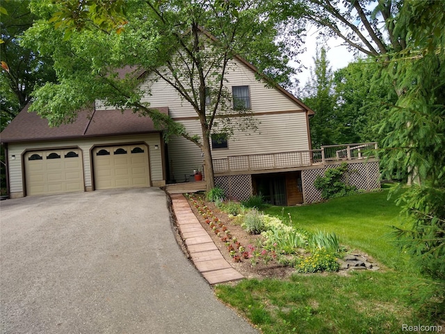 1455 Sand Rd, Port Austin, MI 48467 - view of front of home featuring a deck, asphalt driveway, a front lawn, and a garage