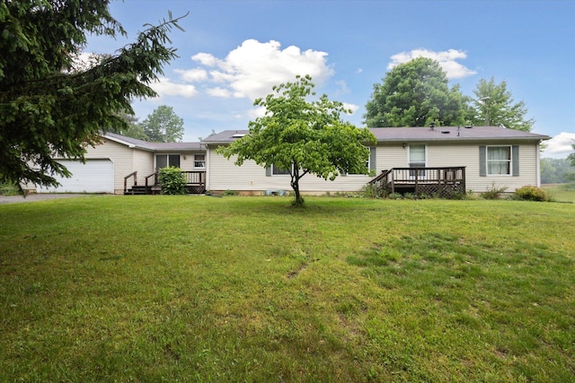 7100 Tripp Rd, Horton, MI 49246 - rear view of house with a wooden deck, a yard, and an attached garage