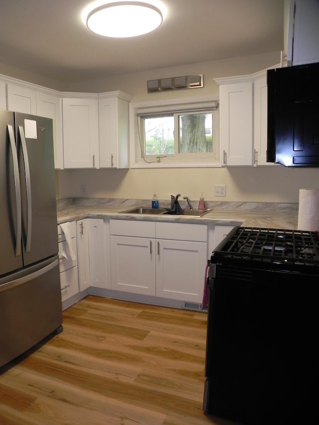 1097 Oliverda Rd, Sherwood, MI 49089 - kitchen featuring freestanding refrigerator, gas stove, a sink, light countertops, and white cabinets