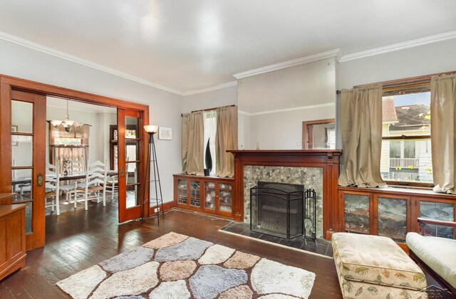 234 N Jackson St, Bay City, MI 48708 - living room featuring wood-type flooring, a chandelier, crown molding, baseboards, and a fireplace