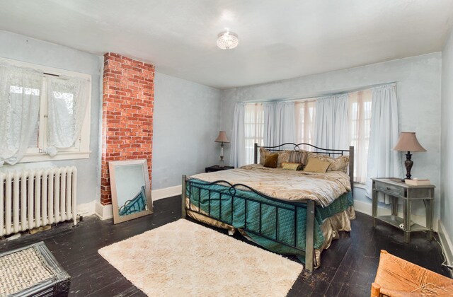 234 N Jackson St, Bay City, MI 48708 - bedroom with radiator heating unit, multiple windows, baseboards, and hardwood / wood-style floors