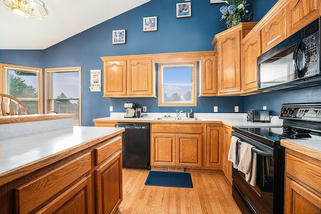 53029 Meadow View Ln, Paw Paw, MI 49079 - kitchen with black appliances, a sink, light wood-style flooring, light countertops, and high vaulted ceiling