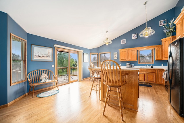 53029 Meadow View Ln, Paw Paw, MI 49079 - kitchen with freestanding refrigerator, a chandelier, light wood finished floors, a kitchen island, and light countertops