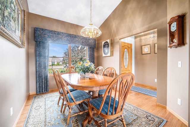 53029 Meadow View Ln, Paw Paw, MI 49079 - dining space featuring a chandelier, light wood-style flooring, baseboards, and high vaulted ceiling
