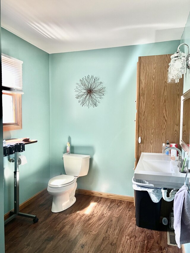 5781 S Waldron Rd, Pittsford, MI 49271 - half bath with wood finished floors, toilet, baseboards, and vanity