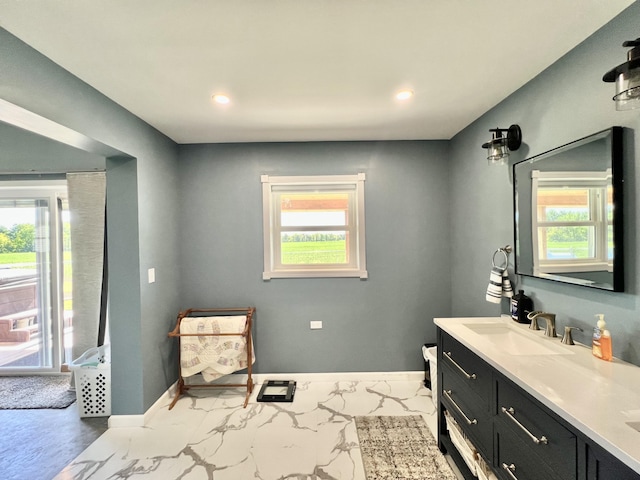 5781 S Waldron Rd, Pittsford, MI 49271 - bathroom with healthy amount of natural light, double vanity, baseboards, recessed lighting, and marble finish flooring